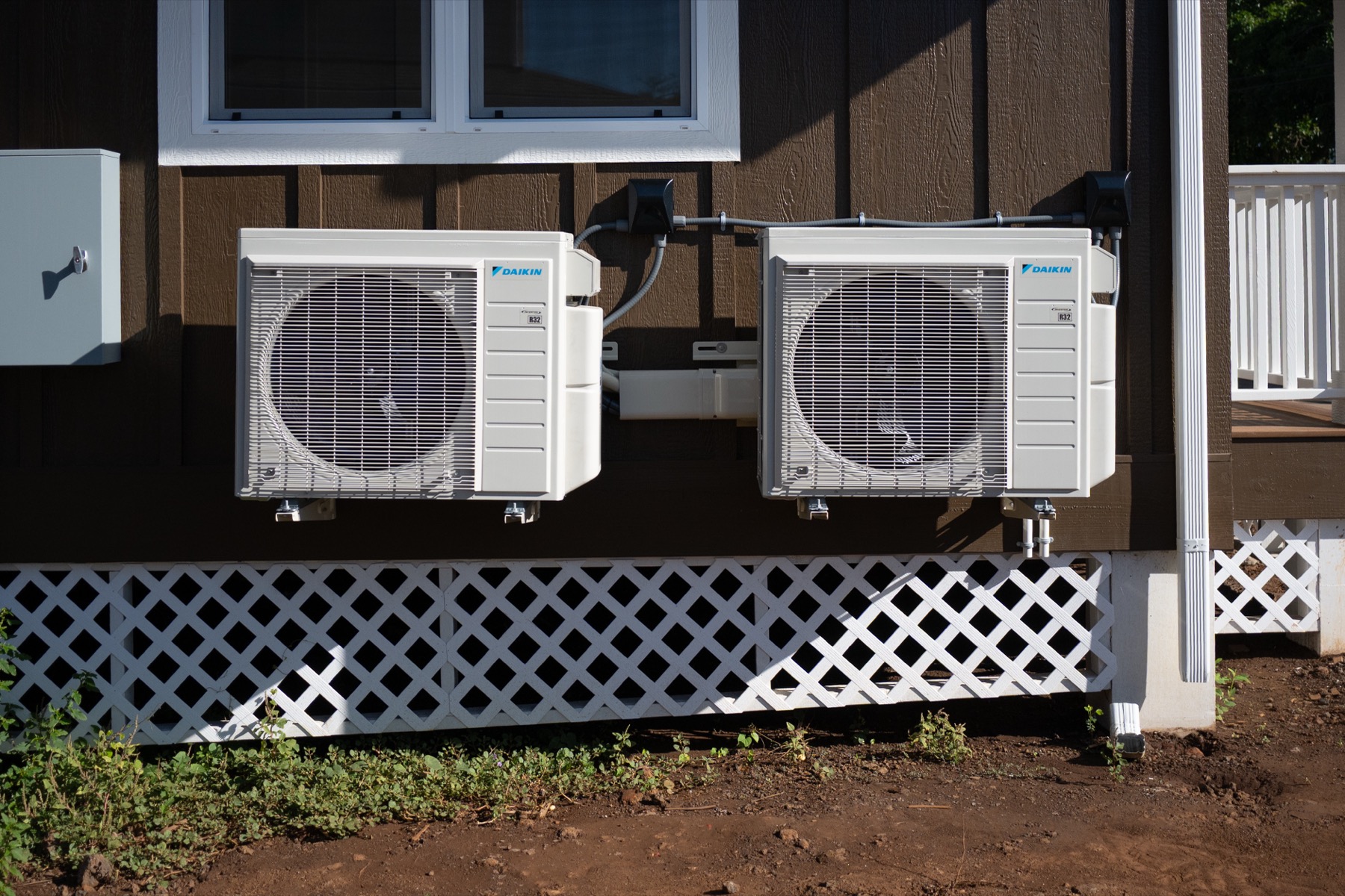 Two Daikin mini split condenser units freshly installed on a Hawaii home, protected before salt air exposure